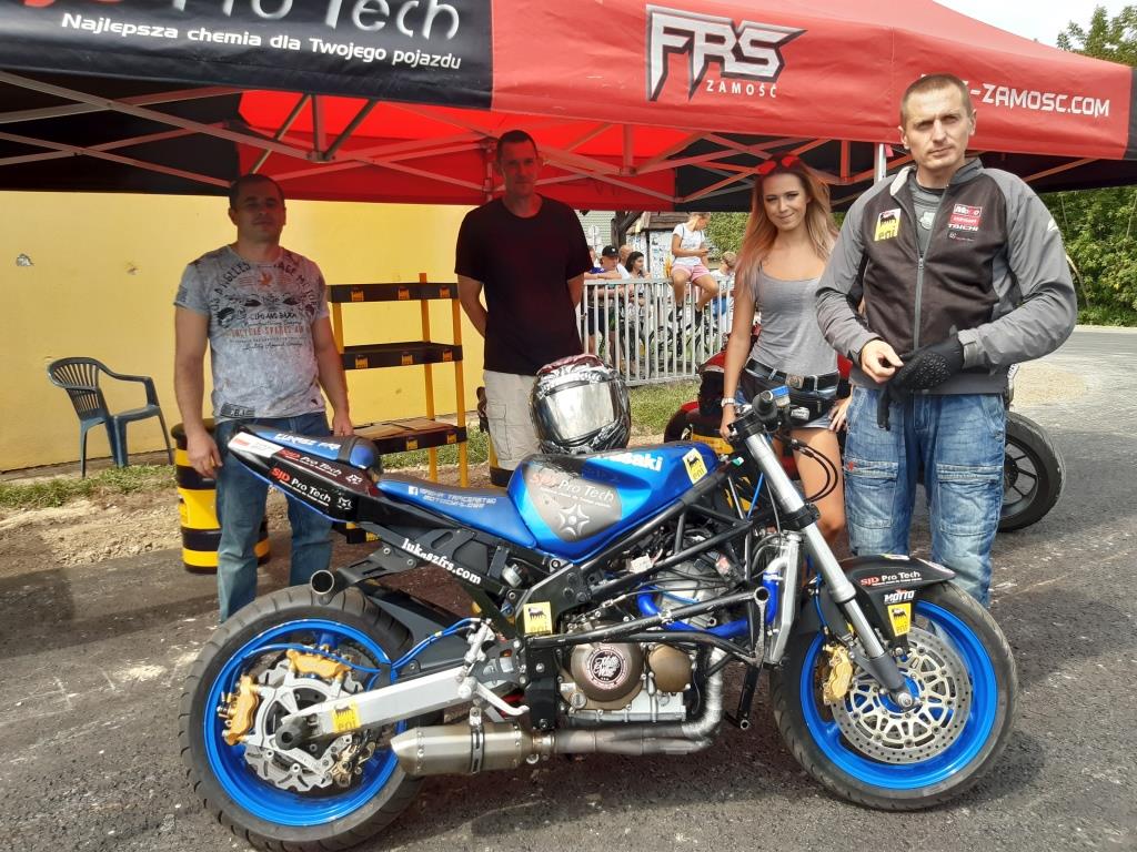 Niebieski motocykl w tle 4 osoby