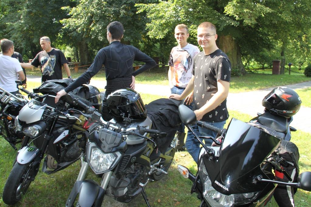 Uśmiechnięci motocykliści, na pierwszym planie motory