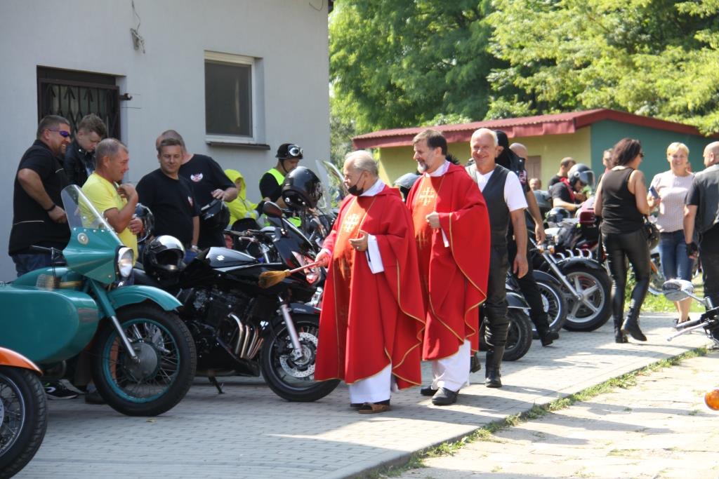  Enlarge Image 	Ksiądz w czerwonej sutannie dokonuje poświęcenia motocykli stojących na dworze 