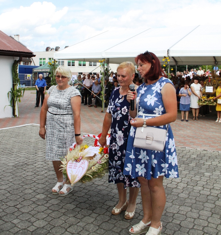 Mały wieniec dożynkowy prezentowany przez 3 kobiety